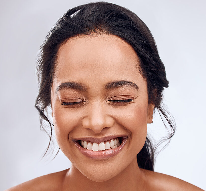 Photo of a smiling woman with closed eyes and great skin