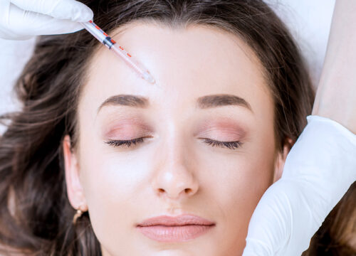Photo of a woman getting a Botox injection in her forehead